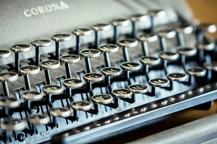 Close-up of an old-fashioned typewriter with the word "CORONA" engraved on it.